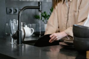 A Person Wearing Long Sleeves Washing Dishes