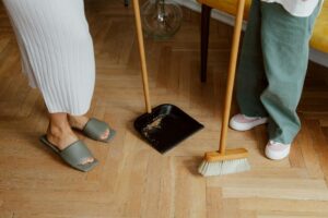Legs of Mother and Daughter Sweeping Floor